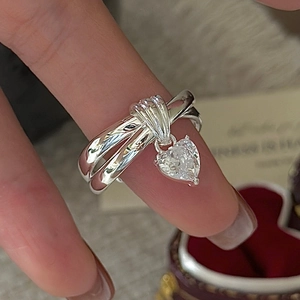 S925 sterling silver layered ring with heart zircon dangle on finger over velvet box