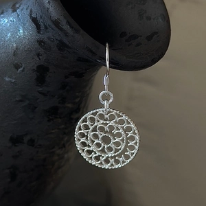 Vintage S925 sterling silver hollow mandala drop earrings on black ceramic display