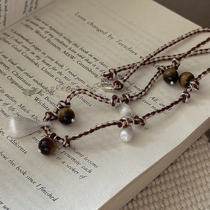 S925 sterling silver beaded necklace with brushed water drop pendant on a vintage book