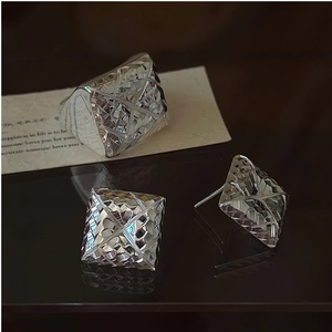 Detailed view of silver geometric jewelry set with pyramid cut ring and earrings