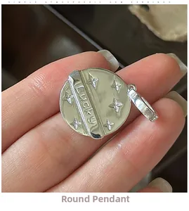 Macro shot of silver S925 round pendant featuring lucky engraving and star patterns