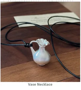 Détail macro d'un pendentif vase en argent vintage avec bord plissé sur cordon noir