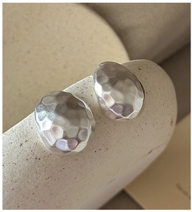 Close-up of S925 sterling silver hammered texture earrings with matte irregular surface