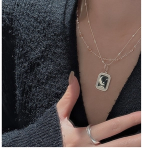 Detail of S925 silver star moon pendant necklace and minimalist ring on a model