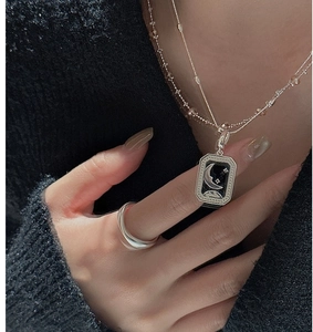 Detailed close-up of retro S925 silver star and moon pendant with minimalist glossy ring