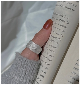 Close-up of wide S925 sterling silver ring with brushed texture on a model finger
