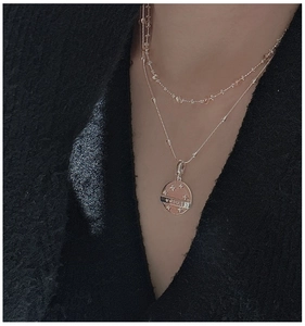 Macro detail of S925 silver layered necklace with Lucky star round pendant on neck