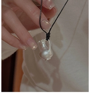 Macro du pendentif vase en argent S925 avec poinçon gravé et cordon tressé noir