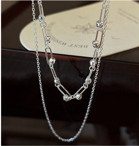 Macro shot of 925 sterling silver double-layered chain with rectangular links and metal beads