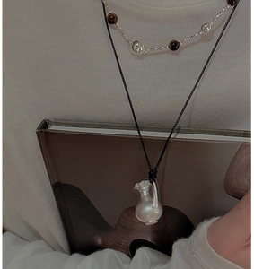 Gros plan du pendentif vase en argent S925 avec perles sur un collier à plusieurs rangs
