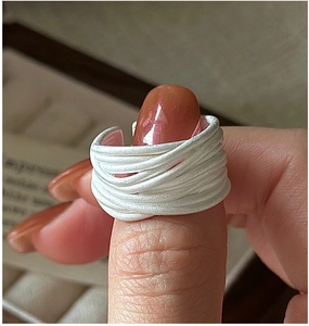 Close-up of a layered S925 sterling silver multi-strand ring with matte texture on finger