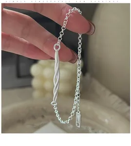 Detail of S925 sterling silver twisted rope chain bracelet on hand with minimalist tag
