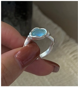 Macro detail of S925 sterling silver hammered ring featuring a translucent blue gemstone
