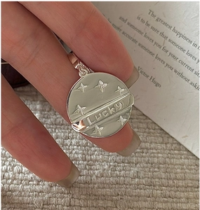Detail of S925 sterling silver lucky round pendant with relief star and lucky engraving