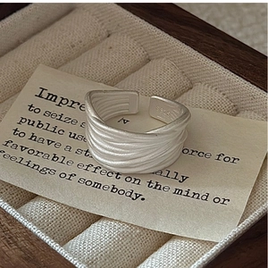 Macro detail of S925 sterling silver multilayer ring on a beige velvet jewelry box tray