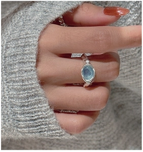 Detail of S925 sterling silver ring with oval aquamarine on model's finger