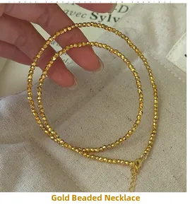 Gros plan du collier de perles dorées en argent S925 avec fermoir mousqueton et chaînette