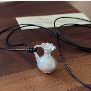 Détail du pendentif vase en argent S925 avec finition brossée mate sur un cordon en cuir noir