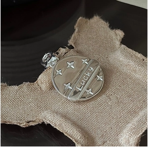 Macro detail of silver Lucky star pendant on vintage kraft paper background