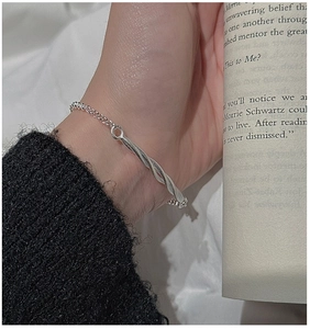 Macro detail of minimalist S925 sterling silver twisted bar bracelet on a wrist