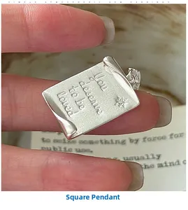 Detailed view of square silver pendant with You deserve to be loved engraving