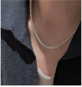 Macro detail of a 925 sterling silver woven galaxy necklace chain on a model