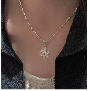 Dettaglio di una collana in argento S925 con ciondolo a fiocco di neve e madreperla