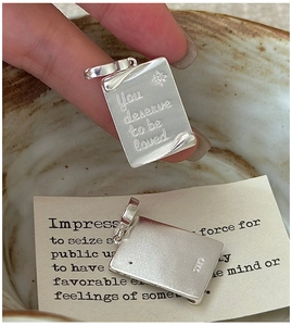 Macro view of S925 silver book-page pendant engraved with You deserve to be loved