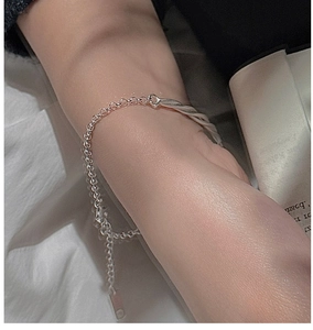 Close-up of S925 sterling silver twisted wire bracelet on wrist with elegant logo tag