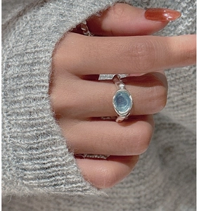 Macro detail of S925 silver ring featuring blue aquamarine and textured liquid metal band