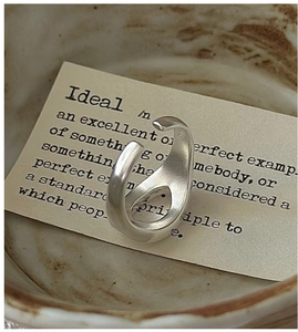 Detailed close-up of S925 sterling silver ring with matte finish on a minimalist card