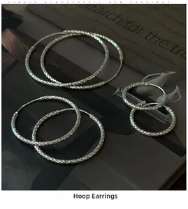 Dettaglio di orecchini a cerchio in argento sterling S925 con faccette geometriche