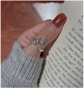 Close-up of S925 sterling silver star ring on a hand with elegant red-brown manicure