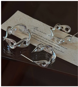 Detailed close-up of S925 sterling silver earrings with irregular fluid curves and texture