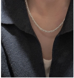 Close-up of S925 sterling silver galaxy chain necklace worn on a black knit sweater