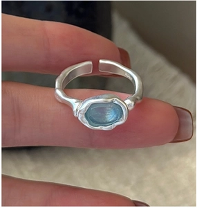 Detailed macro of S925 sterling silver ring with light blue gemstone and lava texture