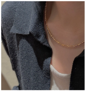 Détail d'un collier en argent S925 doré avec perles à facettes laser porté par un mannequin