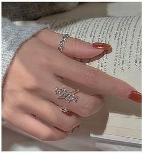 Close-up of S925 sterling silver star ring and hammered band on a female hand