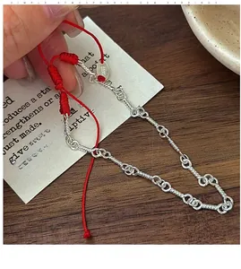 Detail view of red braided cord joined with S925 sterling silver twisted chain bracelet