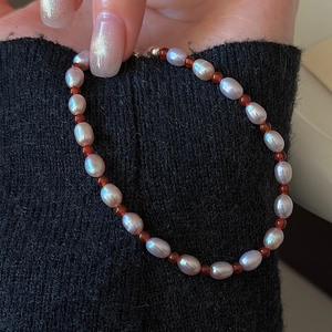 Bracelet en argent S925 avec perles roses et agates rouges porté au poignet