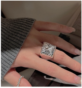 Macro shot of silver CNC square ring with geometric textured surface and beaded ring