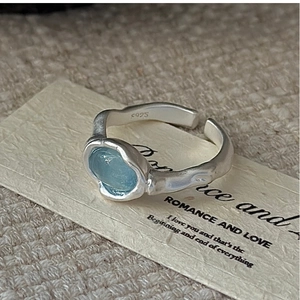 Macro shot of S925 silver ring with oval aquamarine stone and irregular lava texture