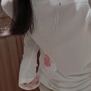 Detail view of handmade S925 silver beaded necklaces with mini bag pendants in pink and white