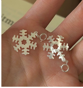 Dettaglio macro dei pendenti a fiocco di neve in argento S925 con intarsio in madreperla