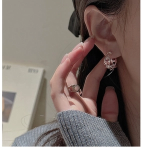 Macro shot of S925 silver pig nose earrings and matching ring with polished mirror finish
