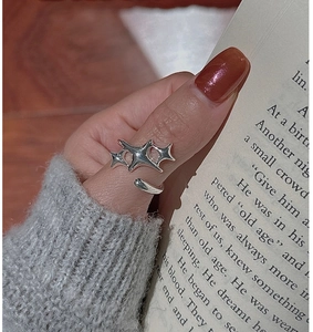 Detail of silver S925 star ring with three sharp stars in y2k punk style on a hand