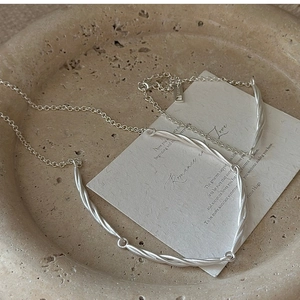 Macro detail of S925 sterling silver twisted chain bracelet on elegant marble tray