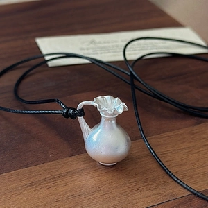 Collier pendentif vase en argent sterling S925 avec cordon noir sur fond de bois sombre