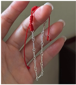 Close-up of S925 sterling silver twisted chain linked with handmade red woven cord