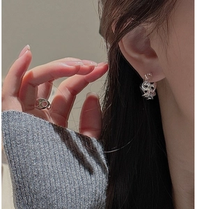 Detail view of silver braided earrings and ring set featuring liquid metal aesthetic